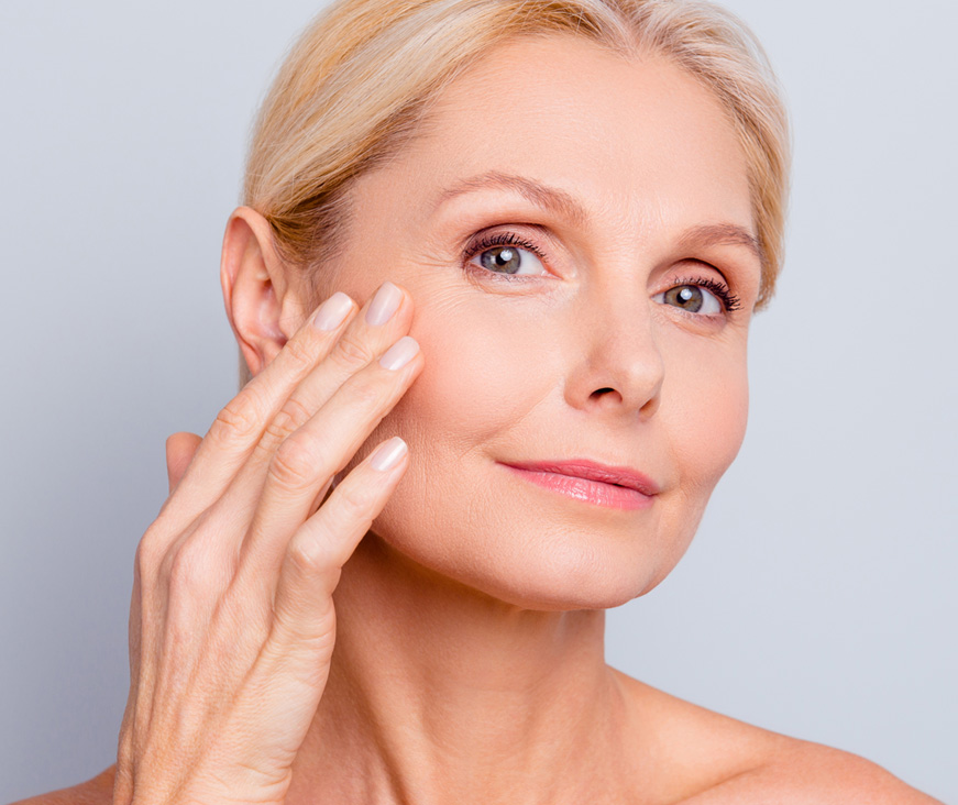 Woman feeling skin of cheek