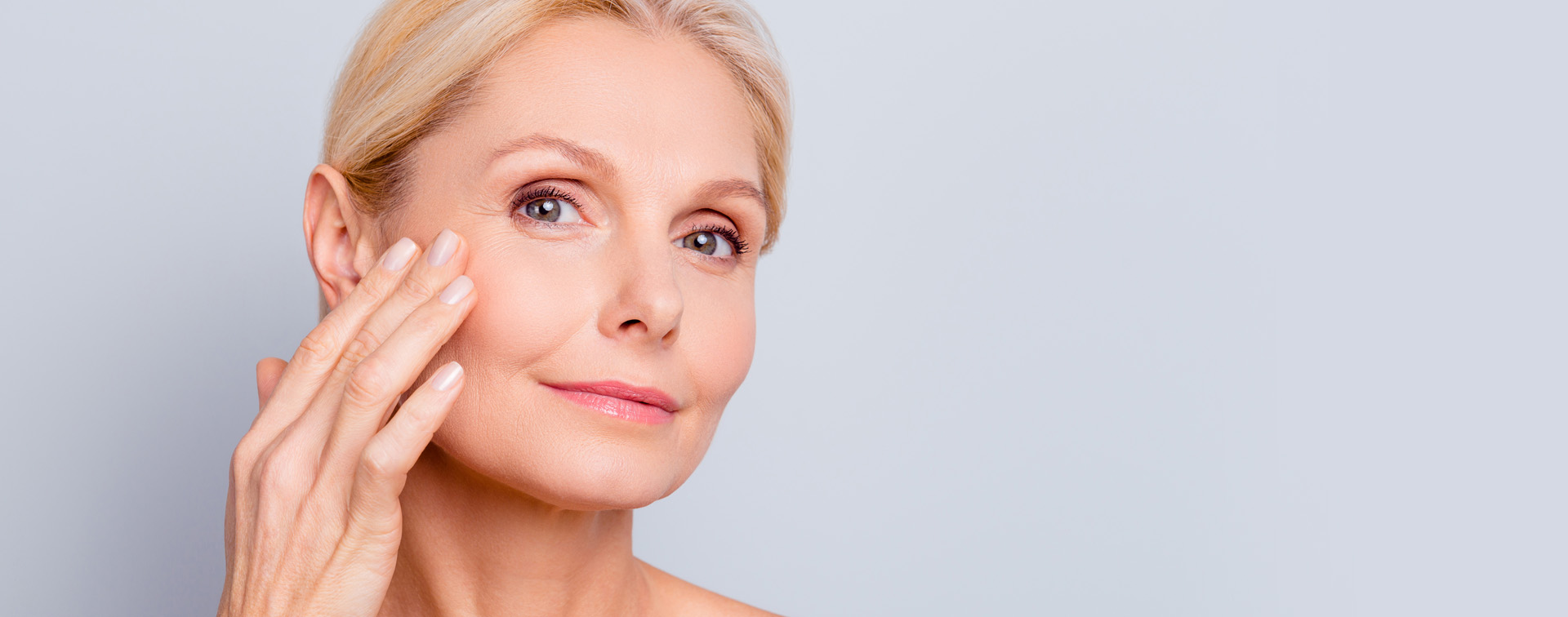 Woman feeling skin of cheek