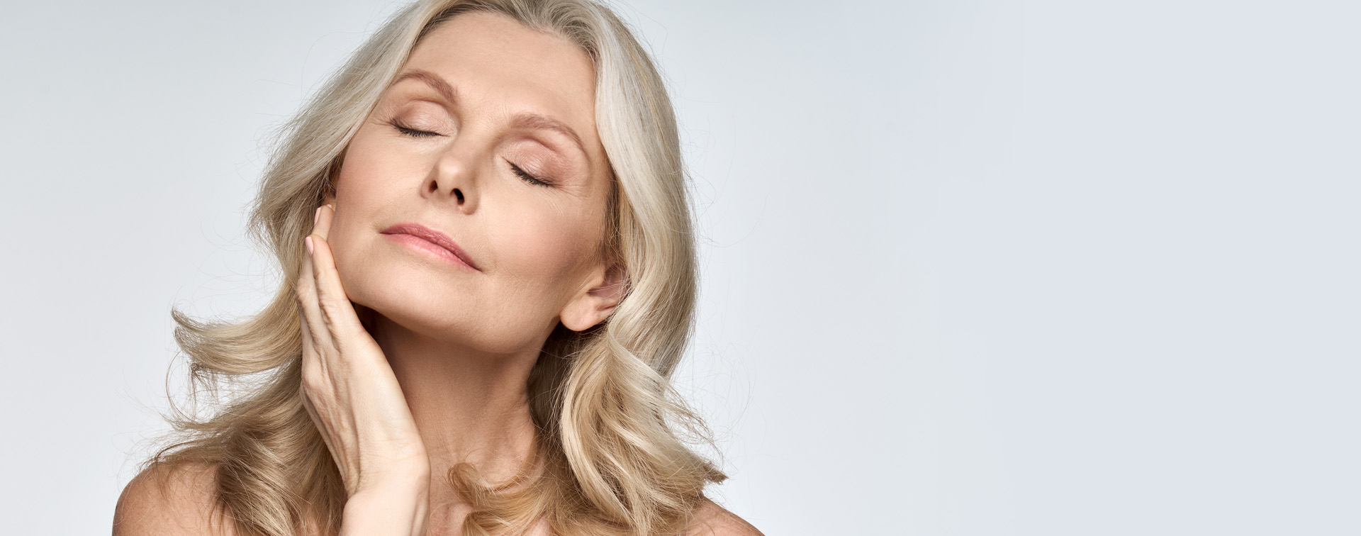 Woman with eyes closed and hand on jaw
