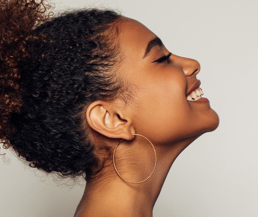 Woman looking up and smiling with eyes closed