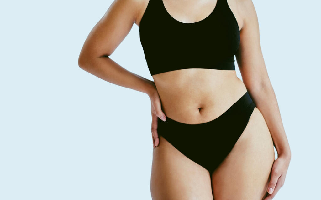 Body of woman in bra and underwear with hand on hip