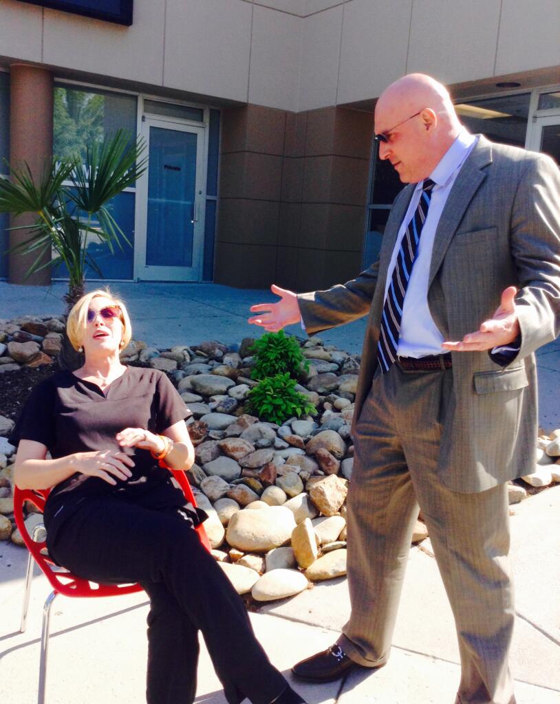 Dr. Lucas motioning confusion to woman sitting in the sun