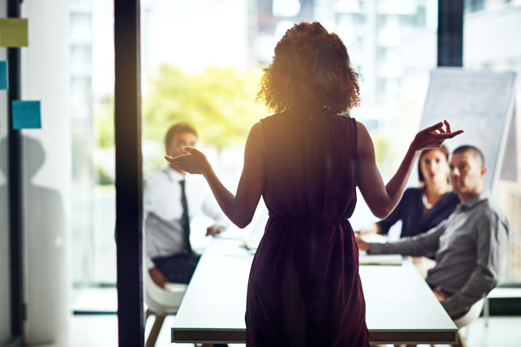 Woman giving a presentation to colleagues in meeting room