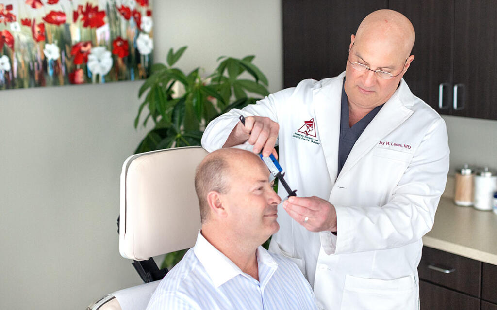 Dr. Lucas measuring patient's nose before rhinoplasty