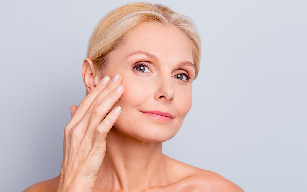 Woman touching cheek inspecting eyelids