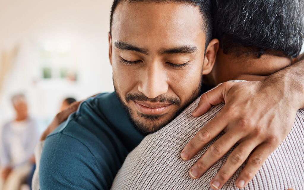 Man embracing another man