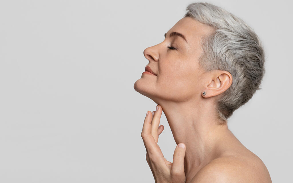 Side profile of woman looking up while touching chin