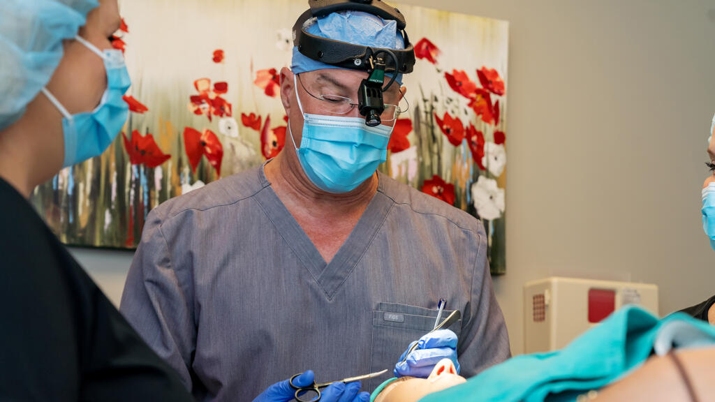Dr. Lucas and assistant performing surgical procedure on patient's face
