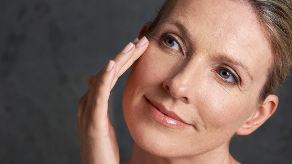 Woman inspecting wrinkles next to eyes