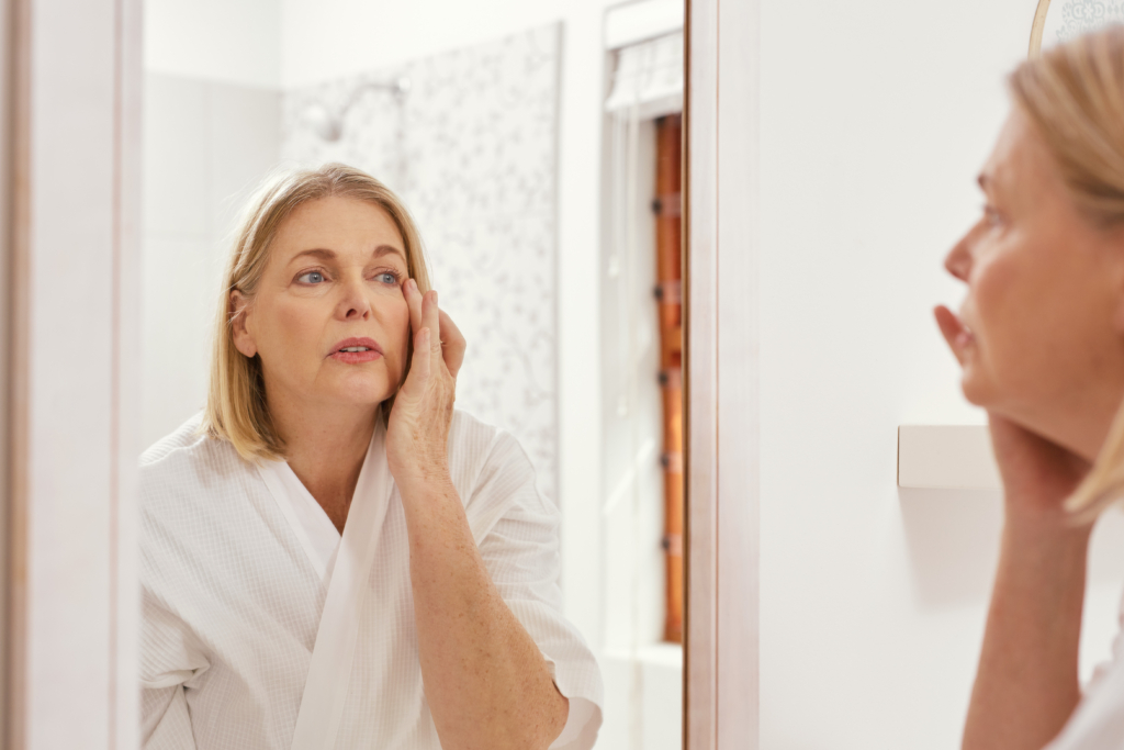 Shot of a mature woman looking at her eye wrinkles in the bathroom mirror
