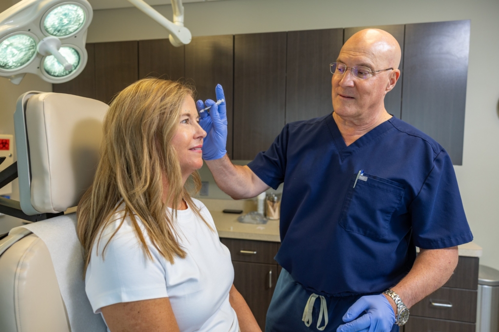 Dr. Jay Lucas preparing a facial injectable treatment for a patient in an exam room at The Lucas Center in Knoxville